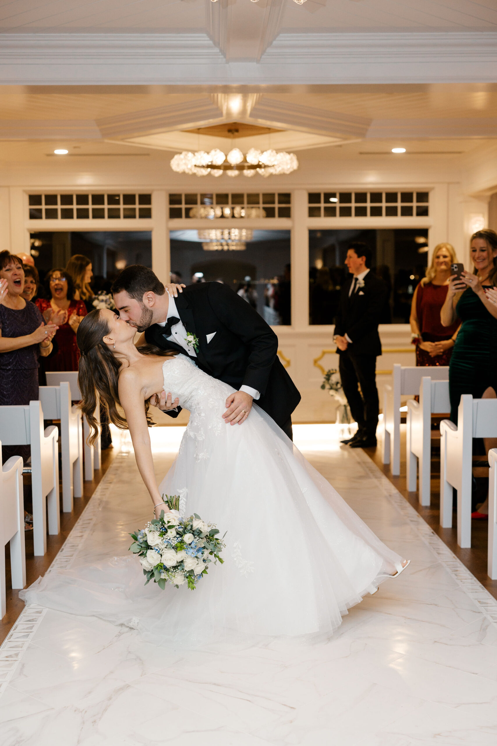 Bride and groom sharing their first kiss at their rainy, winter Crystal Point Yacht Club Wedding in Point Pleasant, New Jersey